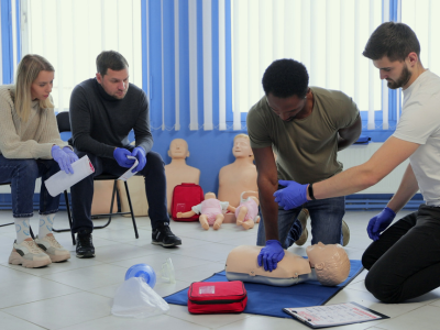 Workplace safety personnel practicing ACLS skills in a simulated emergency response drill.